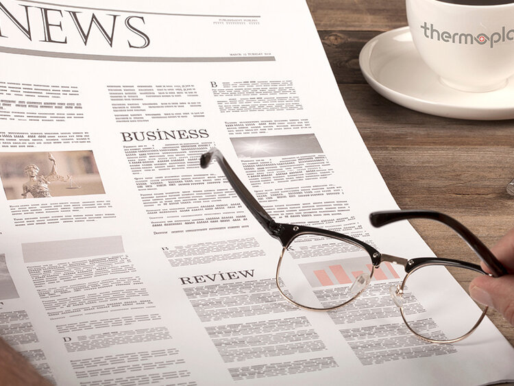 Zeitung mit Kaffee und Brille auf Holztisch