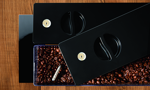 Lockable bean container with coffee beans on a wooden table