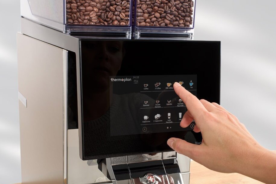 Finger betätigt Touchdisplay an einem Kaffeevollautomaten