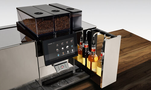 Fully automatic coffee machine with syrup on a wooden table