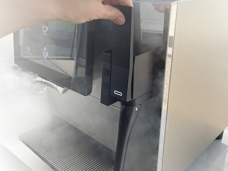 Hand operates the steam lance of a fully automatic coffee machine