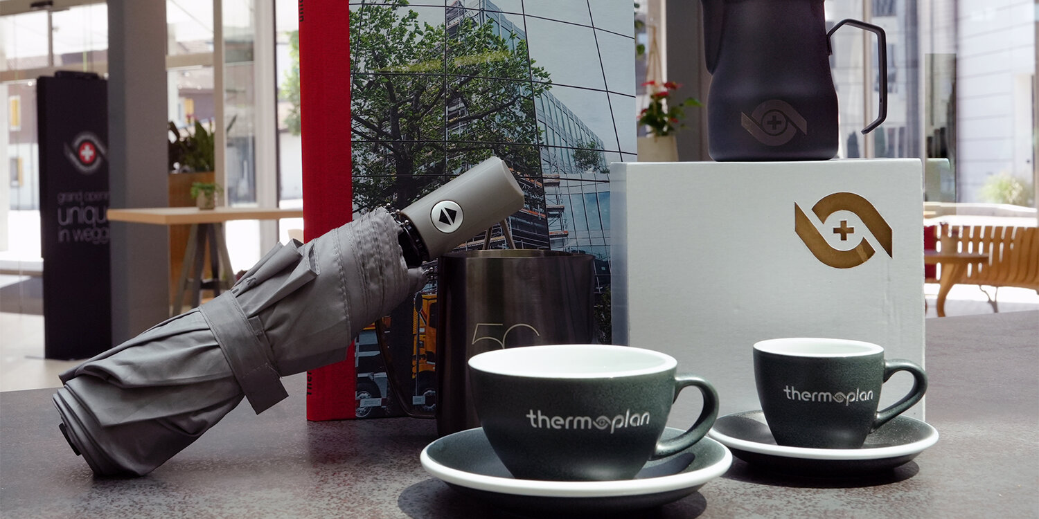 Buch, Tassen, Pitcher und Regenschirme als Merchandise Artikel mit Thermoplan Logo