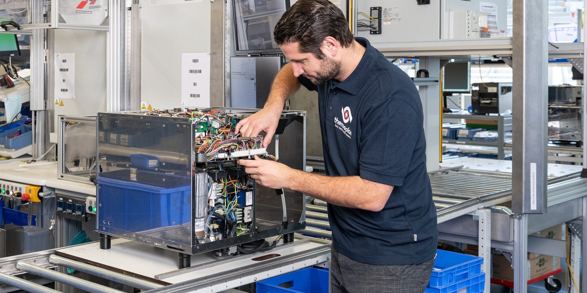 Produktionsmitarbeiter montiert eine Kaffeemaschine