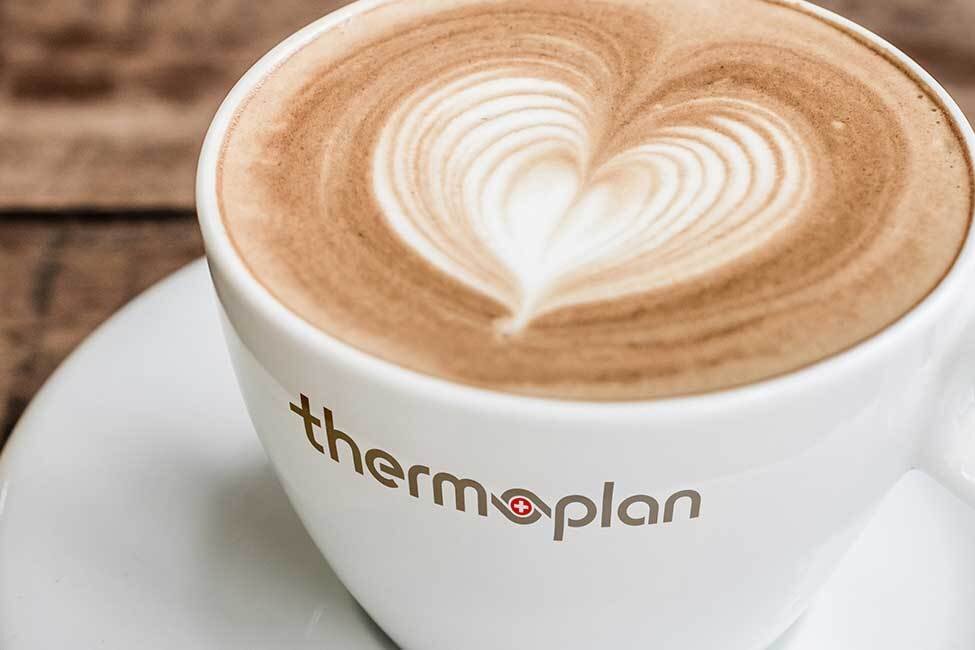 Latte Art Herz in weisser Tasse auf Holztisch