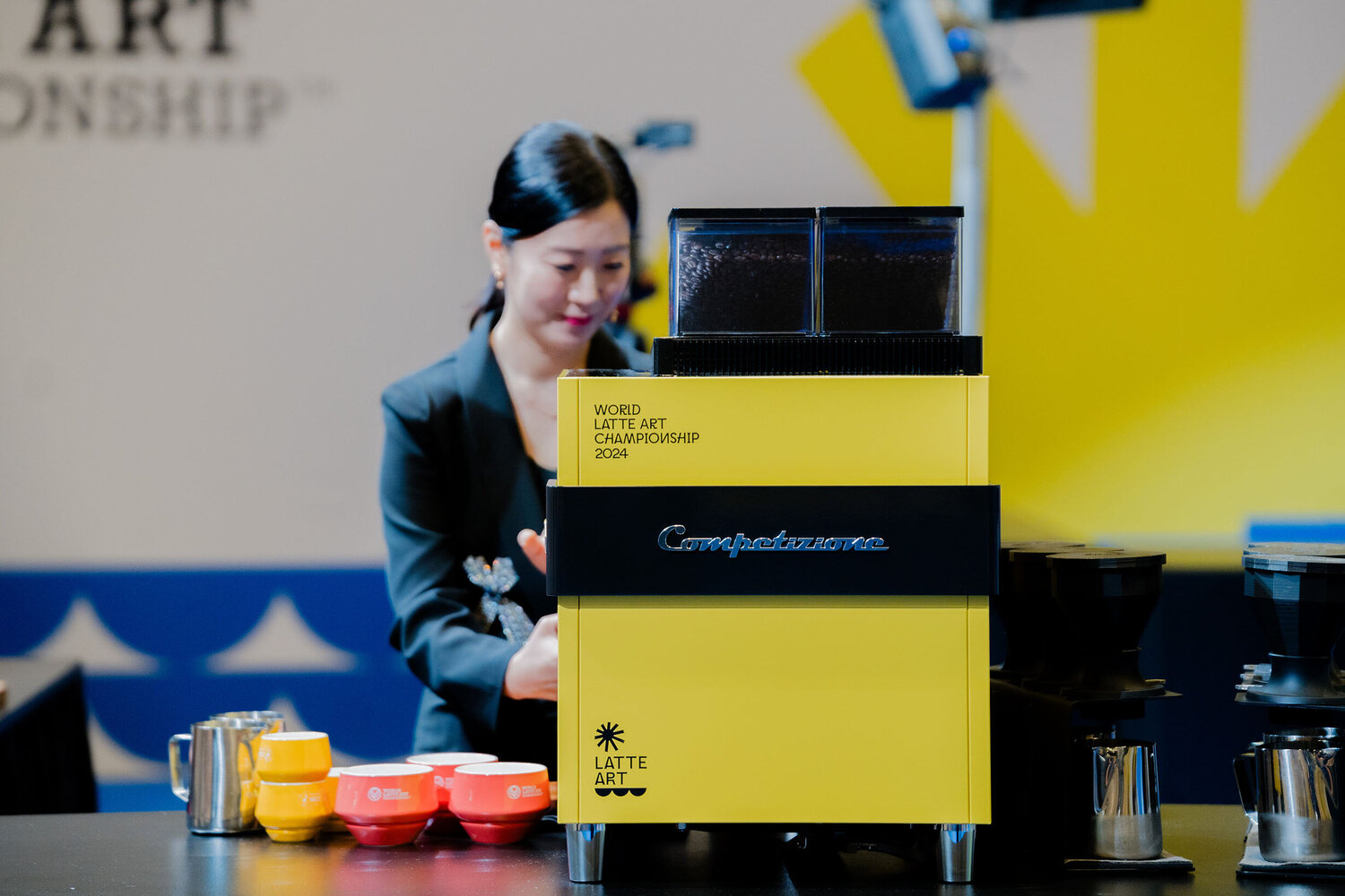 Barista foams milk on fully automatic coffee machine